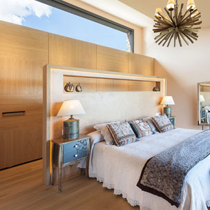 Carpinteria BRAIPONT: Cabezal de cama con marco de roble y leds incorporados. Armario vestidor con puertas correderas coplanares.