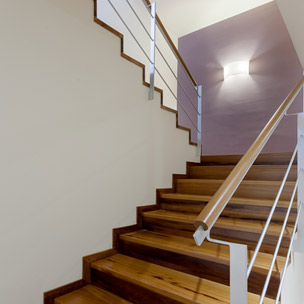Carpinteria BRAIPONT: Escalera de iroko con pasamano redondo.